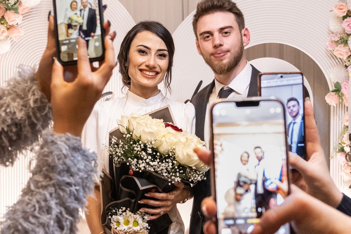 Wedding guests filming the couple on their phones