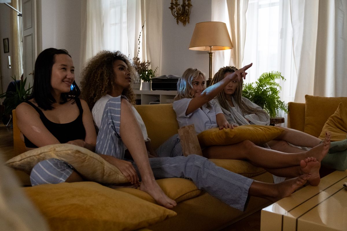 Friends watching something together on a sofa